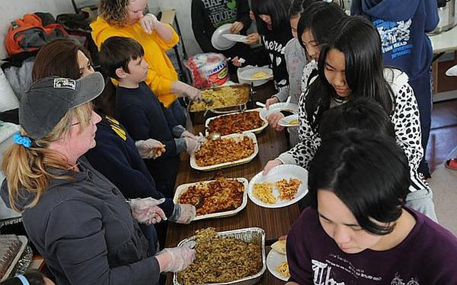 Children at Bikou-en Children’s Care House wait in line for a home-cooked meal March 27, delivered by members of Naval Air Facility Misawa.