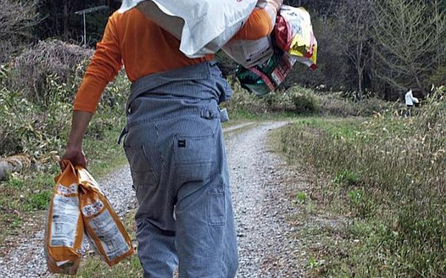 A volunteer from Dogs and Cats Orphan Support delivers pet foods to the border of the 12-mile no-go radius around the battered nuclear plant in Fukushima. 