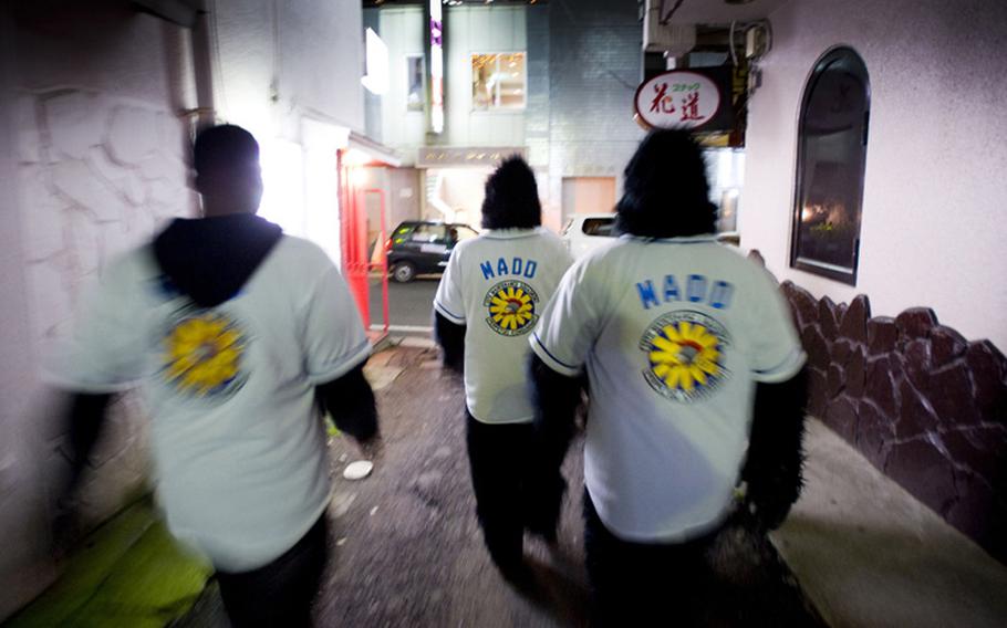 Members of Maintenance Monkeys Against Drunk Driving walk through an alley in downtown Misawa in late 2009 to offer free rides home in an effort to curb drinking and driving in the local community. 