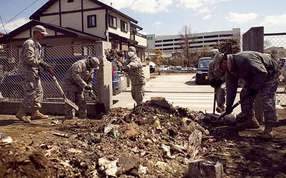 Soldiers from Logistics Task Force 35, shovel debris from a school yard in Ishinomaki, Japan, following the March 11 earthquake and tsunami. Military health officials say that air, water and soil samples tested in the region in April did not contain dangerous levels of toxins or radiation.