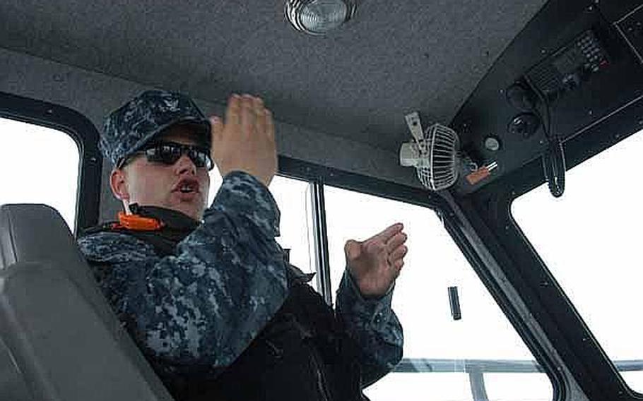 Petty Officer 3rd Class Richard Wood offers some guidance to Seaman Apprentice Corrine Roberts, who is new to Sasebo Naval Base and harbor security. The harbor security team works around the clock to keep U.S. Navy assets in the area safe.