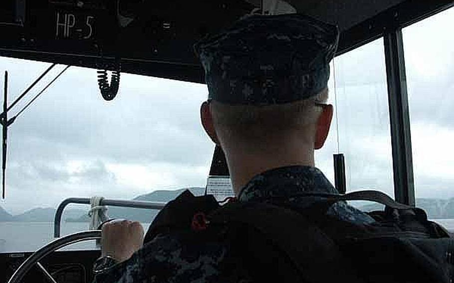 Petty Officer 2nd Class Ryan Blazer surveys his surroundings while on a mid-June patrol of the harbor near Sasebo Naval Base, Japan. Blazer is part of the Sasebo harbor security team charged with keep U.S. Navy assets in the area safe.