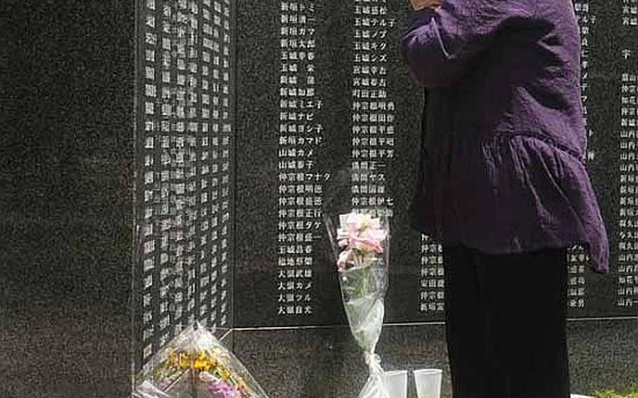 A woman offers prayers at Peace Prayer Park on Wednesday, the anniversary of the end of the Battle of Okinawa. More than 240,000 names are inscribed on the granite walls, memorializing all those that lost their lives.