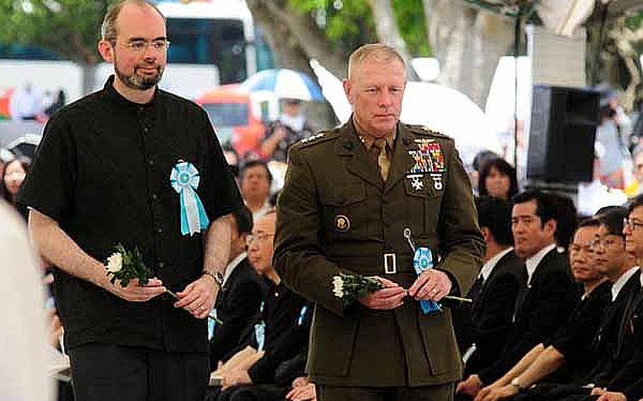 Raymond F. Greene, Consul General Consulate General of the United States, Okinawa, left, and 
Lt. Gen. Kenneth J. Glueck, Jr. commanding general of III Marine Expeditionary Force and Marine Corps Bases Japan, get ready to place chrysanthemums at a table during the Battle of Okinawa memorial service held Thursday at the Peace Prayer Park in Itoman.