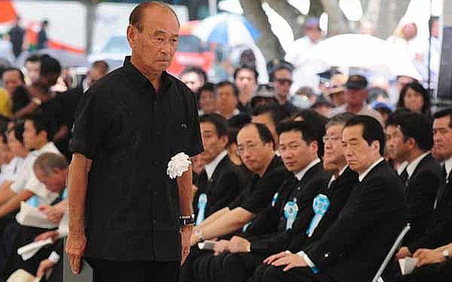 Okinawa Governor Hirokazu Nakaima finishes his bow to government officials after placing a chrysanthemum on a table during the Battle of Okinawa memorial service Thursday at the Peace Prayer Park in Itoman.