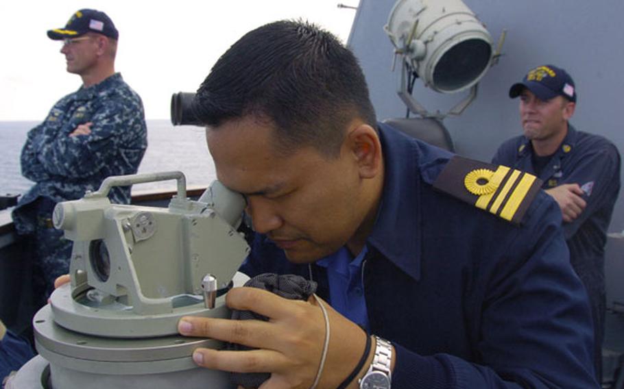 Royal Malaysian Navy Lt. Cmdr. Emmry Shahril peers at a ship formation aboard USS Howard during a bilateral exercise in the South China Sea on June 13. Recent incidents between Chinese vessels and other nations in the sea, which China claims most of as its sovereign territory, have led Southeast Asian nations to seek closer ties with the U.S. Navy.