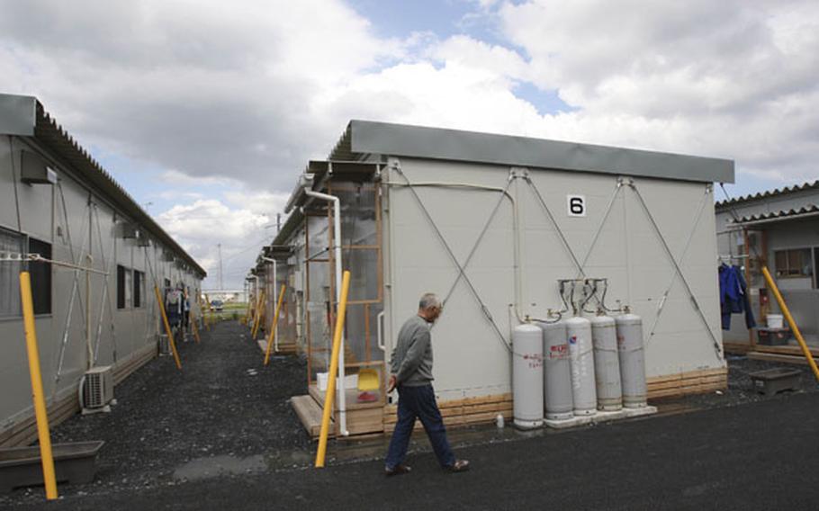 An elderly man walks by rows of temporary housings for the March 11 earthquake and tsunami survivors at Hibiki Industrial Park in Higashimatsushima, Miyagi Prefecture, northeastern Japan, June 14.