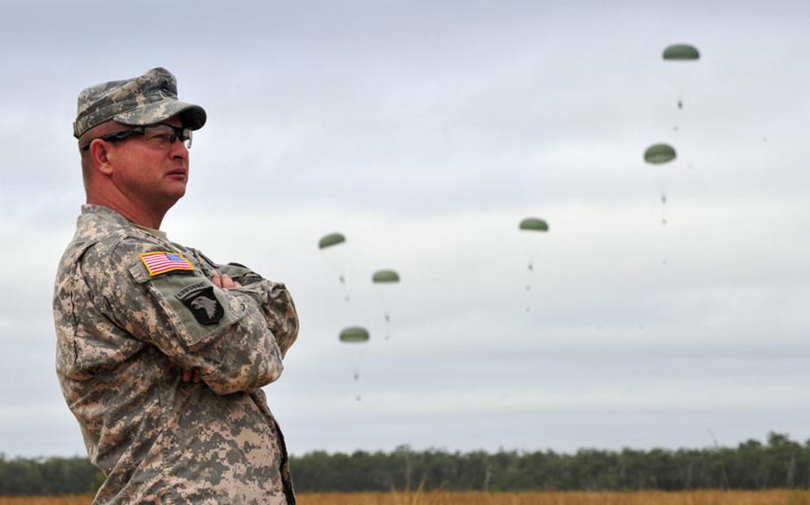 Master Sgt. Adam Smith, U.S. Army Pacific Exercise Division, observes paratroopers from the 1st/501st Infantry Regiment descend into Drop Zone Kapyong on Sunday. Smith was the lead planner for the drop, overseeing the event from start to finish. Around 300 soldiers jumped for Exercise Talisman Sabre 2011 on 17 July.