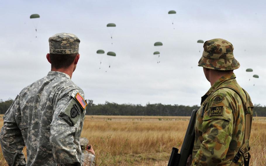 U.S. Army Sgt. Ian Rhines and Australian Craftsman Tyler Kernahan watch the airborne insertion of US troops Sunday from the 1st/501st Infantry Regiment into Drop Zone Kapyong as part of Exercise Talisman Sabre 2011.