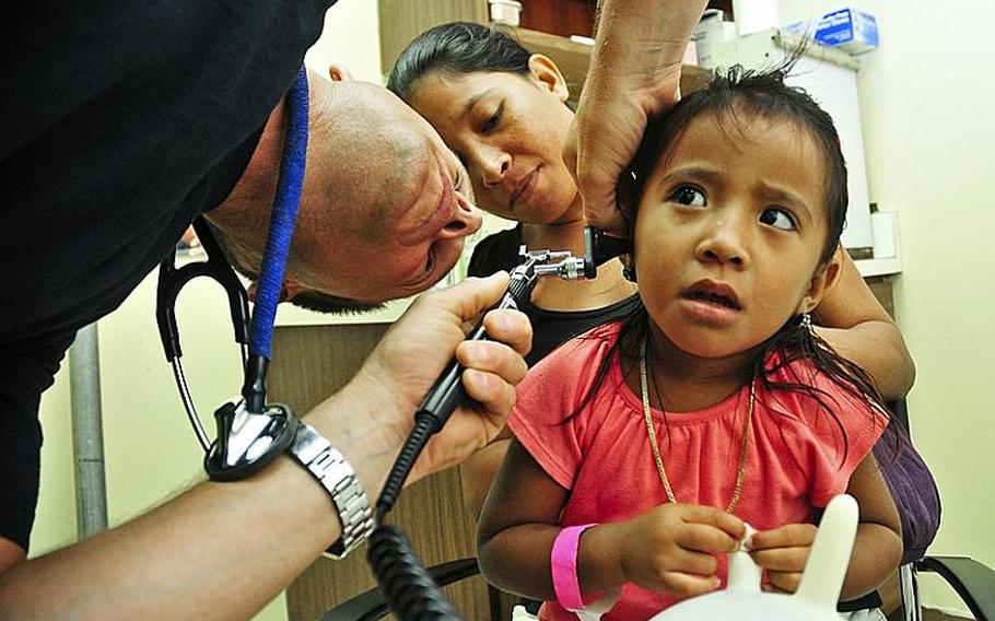 Lt. Cmdr. Cory Russell examines the ear of a Micronesian girl at Pohnpei Hospital during a Pacific Partnership 2011 medical community service project. Pacific Partnership is a five-month humanitarian assistance initiative that will make port visits to Tonga, Vanuatu, Papua New Guinea, Timor-Leste and the Federated States of Micronesia.