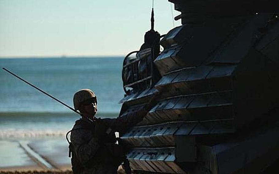 Marines with Company G., Battalion Landing Team 2nd Battalion, 7th Marines, 31st Marine Expeditionary Unit, communicate beside an amphibious assault vehicle at Freshwater Beach during an amphibious assault exercise in Australia. One of the biggest and most comprehensive operations of the ongoing exercise, the amphibious assault featured a beach assault and airfield seizure with real world obstacles, including everything from enemy ambushes to simulated IED blasts.