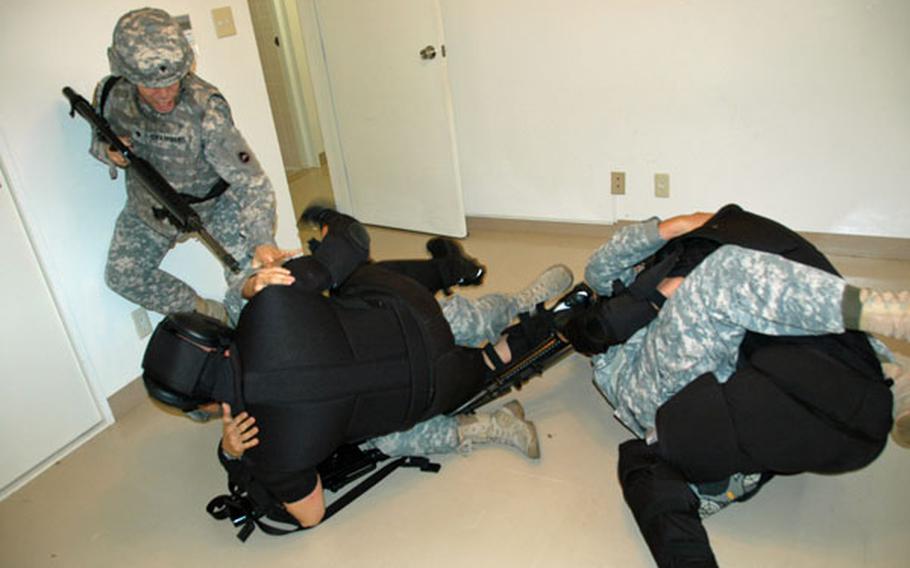 A three-person team battles two instructors posing as insurgents inside a house at Camp Zama during Army Combatives Level II training on July 19, 2011.