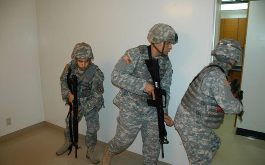 A team of three soldiers clears rooms in a house during Army Combatives Level II training at Camp Zama in July 2011.