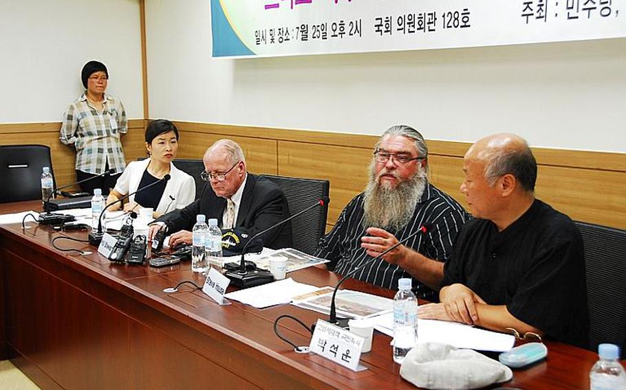 Veteran Steve House, second from right, testifies before South Korea&#39;s National Assembly on Monday. House claims he buried Agent Orange at Camp Carroll in 1978, though the military is still investigating his allegations. Sitting beside him, to his right, is Phil Steward, a second U.S. veteran who claims the U.S. military widely sprayed Agent Orange in and around U.S. bases in South Korea when he was stationed there 42 years ago.