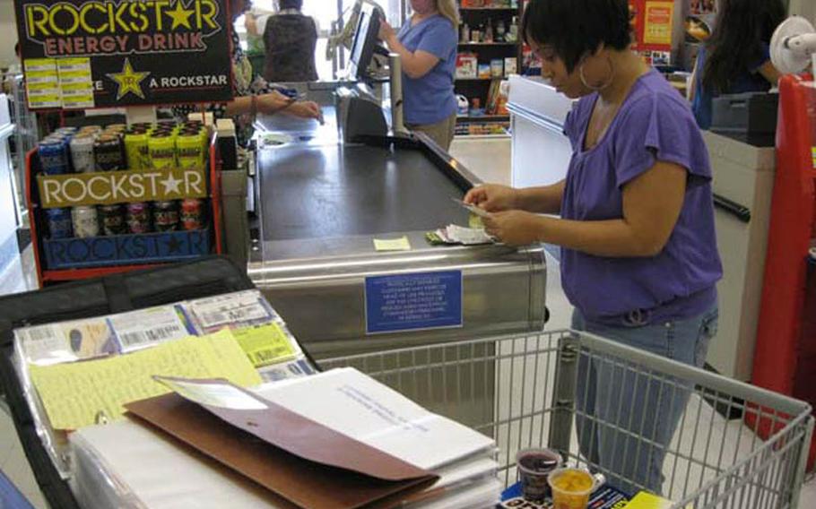 Aprille Caesar, an Air Force wife and mother of two, uses a coupon binder to keep track of potential savings during a commissary visit at Yokota Air Base, Japan, in June. Caesar says she has reduced her average grocery bill by about 30 percent since she began using coupons a few months ago.