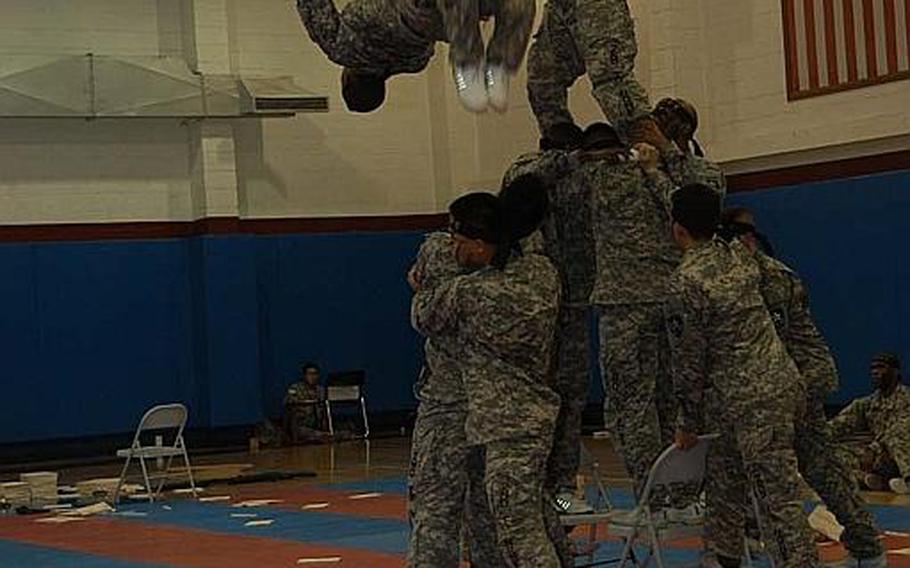 Pfc. Christopher Brown does a backflip while delivering kicks to two boards being held more than 10 feet in the air during a performance by the 2nd Infantry Division's Tae Kwon Do Demonstration Team on Aug. 3, 2011, at Camp Red Cloud in South Korea. The 28-member team works full time preparing for about 15 demonstrations each year.