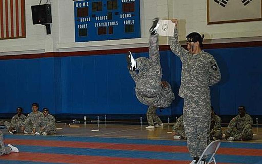 Pfc. Christopher Brown delivers a flip-kick to a board being held aloft during a performance Aug. 3, 2011, by the 2nd Infantry Division's Tae Kwon Do Demonstration Team in South Korea.