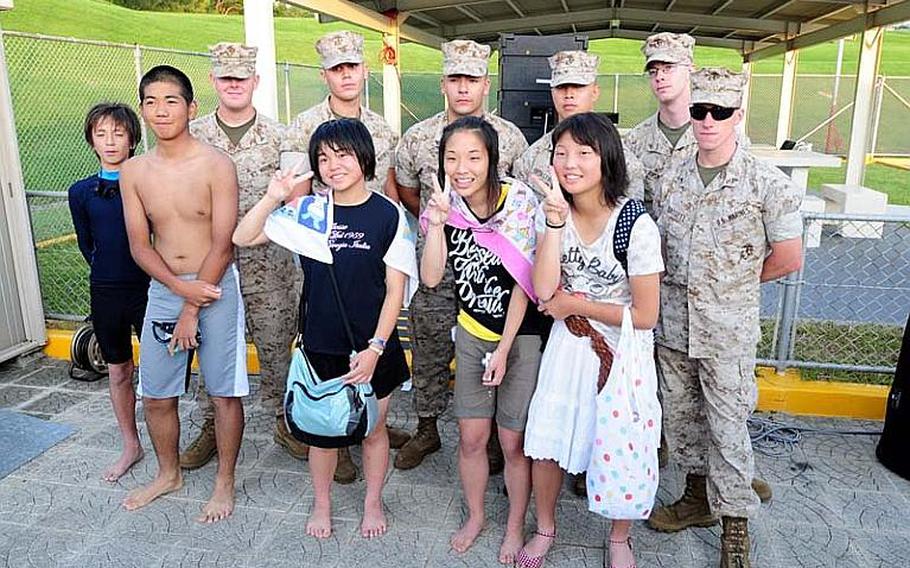 Marines pose with school children who visited Okinawa as part of a four-day cultural exchange/homestay program sponsored by Marine Corps Base Japan. The children are from Oshima District, Kesennuma City, Miyagi Prefecture and their town was heavily damaged in the March 11 East Japan Great Earthquake.