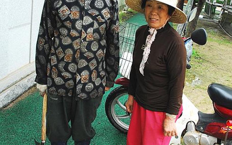 Kim Dong-gyu, left, and his wife take a break during a day of farming in Taesongdong. Kim, 72 and a lifelong resident of Taesongdong, said the village was terrorized by Chinese troops during the Korean War, and said he worries more about losing his land someday than a North Korean attack.