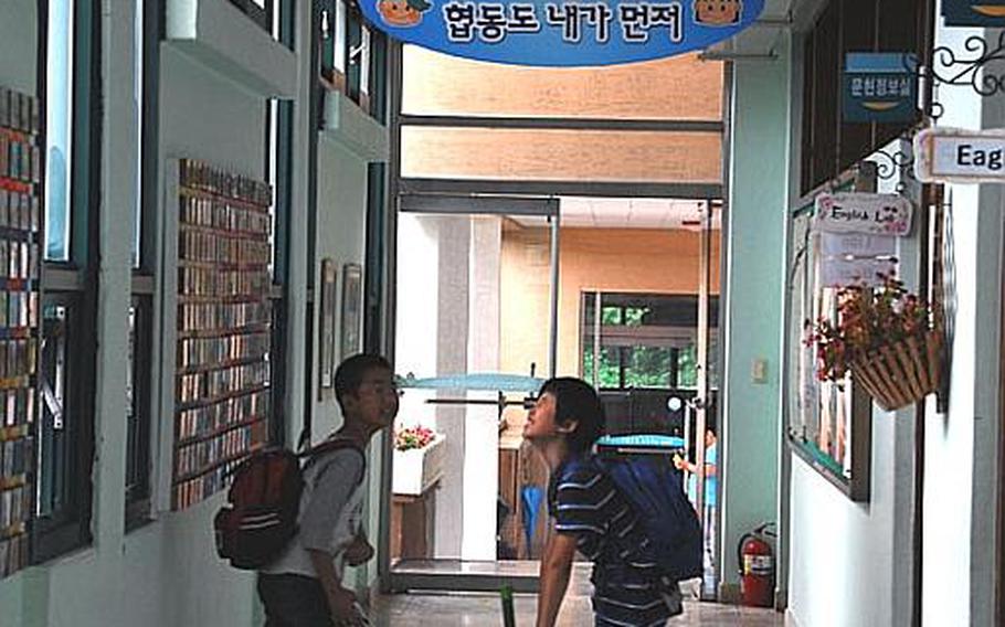 Two students joke in the halls of Taesongdong Elementary School as they leave the building at the end of the day.