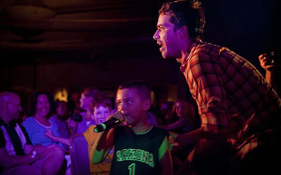 Past American Idol contestant Colin Benward shares the microphone with a young fan Wednesday night during a performance at Yokota Air Base.