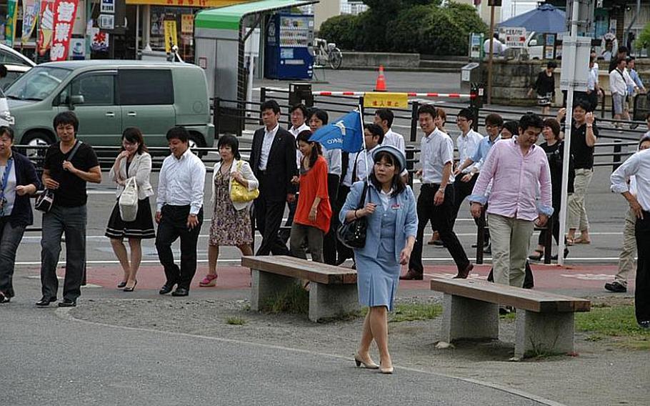 Some of the first tourists to return to Matsushima, Japan, after the March earthquake and tsunami follow a tour group leader on Aug. 24, 2011.