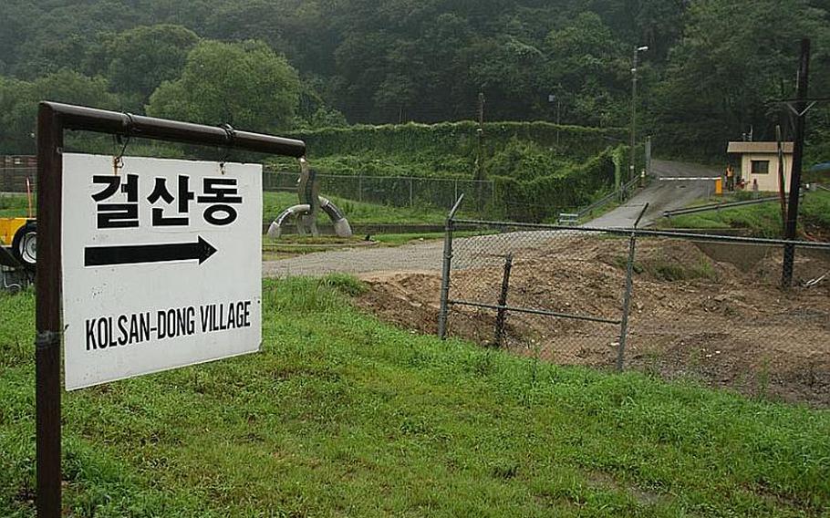 A sign on Camp Casey in South Korea points the way out Gate 11 and up a hill to Golsandong Village, where about 130 are essentially landlocked between the base and the nearby mountains. Because of that, village residents are issued passes that allow them 24-access to cut through Camp Casey going to or from the outside world. Korean words are sometimes spelled different ways when translated into English, thus accounting for the alternate names of the village.