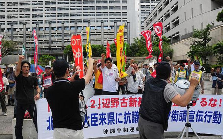 Approximately 150 protesters demonstrate outside the Prefectural Government Office in Naha, Okinawa, in this May file photo. Despite such protests, which have become commonplace on the island, Japan&#39;s new government says it intends to move forward with plans to relocate Marine Corps air operations from Futenma to Camp Schwab.