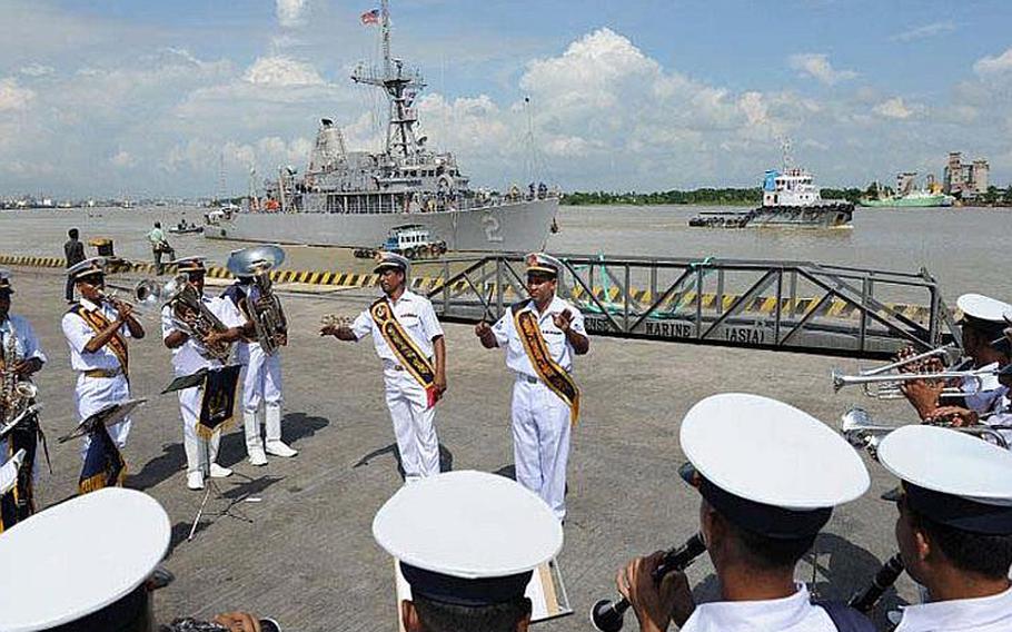 The Bangladesh navy band performs on the pier Sept. 18, 2011, as the Sasebo-based mine countermeasure ship, USS Defender, maneuvers to arrive in Chittagong. The USS Defender is in Chittagong for Cooperation Afloat Readiness and Training (CARAT) Bangladesh 2011. CARAT is a series of bilateral exercises held annually in Southeast Asia to strengthen relationships and enhance force readiness. CARAT Bangladesh 2011 marks the first time the Bangladesh navy has participated in the exercise series.