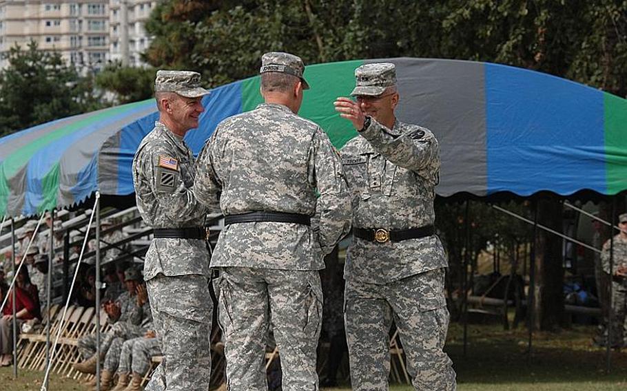 Eighth Army commander Lt. Gen. John Johnson, center, shakes hands with outgoing 2nd Infantry commander Maj. Gen. Michael Tucker, right, at a change of command ceremony Tuesday at Camp Casey in South Korea. Maj. Gen. Edward Cardon, left, assumed command of the division at the ceremony.