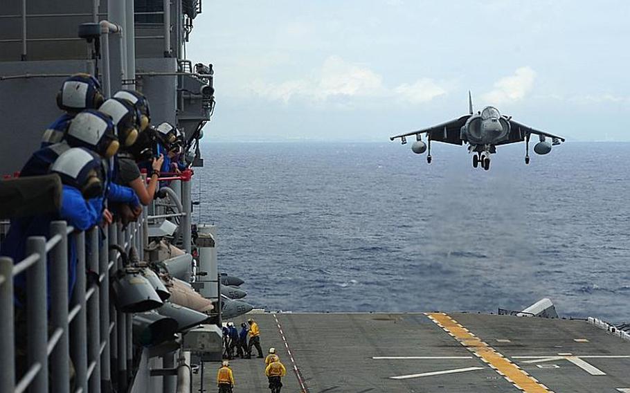 Aviation boatswains mates watch from vulture&#39;s row as an AV-8B Harrier with Marine Attack Squadron 214 lands on the flight deck of the forward-deployed amphibious assault ship USS Essex Sunday. Essex is part of the Essex Amphibious Ready Group, which is currently on patrol in the western Pacific.