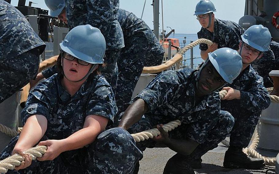 Seaman Brooke Haney, Seaman Recruit Travis Abankwah, and Seaman Recruit Dustin Davidson pull on a line Friday while mooring at West Army Pier in Okinawa, Japan aboard the amphibious dock landing ship USS Germantown. The Germantown is part of the Essex Amphibious Ready Group, which is currently on patrol in the western Pacific.