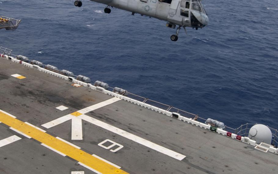 A CH-46E Sea Knight from Marine Medium Helicopter Squadron 265 takes off from the flight deck of the forward deployed amphibious assault ship USS Essex while operating in the Philippine Sea to take part in a simulated air raid on Oct. 2, 2011.
