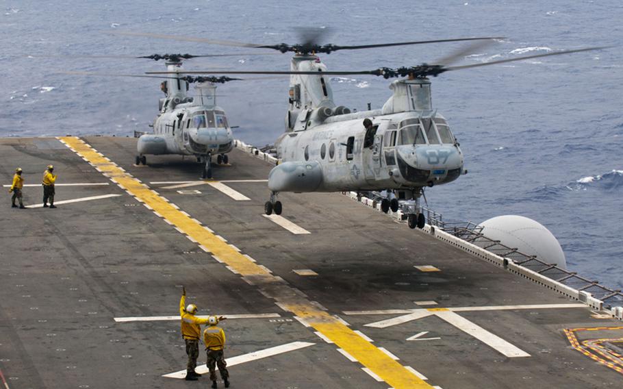 CH-46E Sea Knights from Marine Medium Helicopter Squadron 265 take off from the flight deck of the forward deployed amphibious assault ship USS Essex, operating in the Philippine Sea, to take part in a simulated air raid Oct. 2, 2011.
