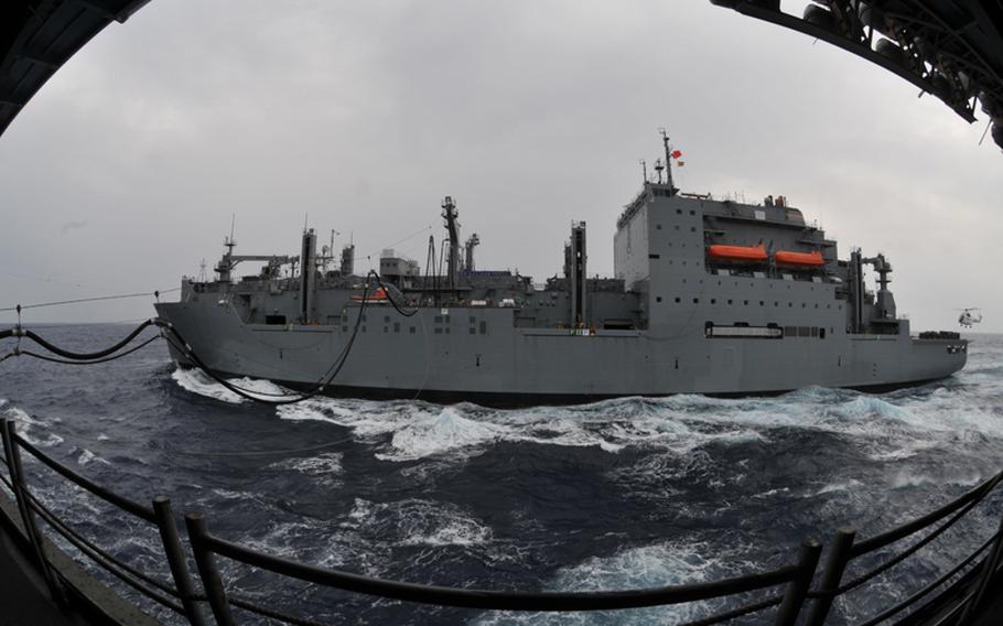 The dry cargo/ammunition ship USNS Matthew Perry conducts a replenishment at sea with the forward-deployed amphibious assault ship USS Essex in the Philippine Sea on Oct. 3, 2011.