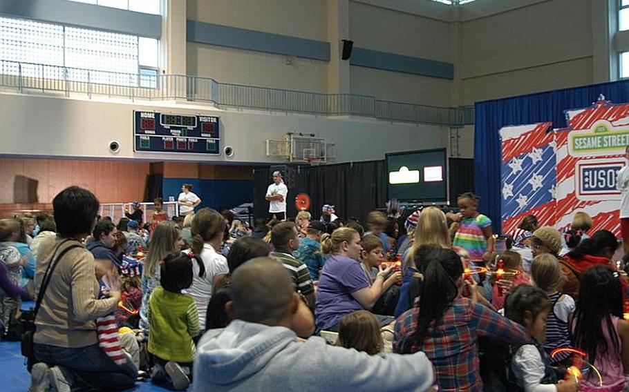 Military families fill the Fleet gymnasium at Sasebo Naval Base, Japan, on Oct. 6, 2011, for a Sesame Street/USO show.