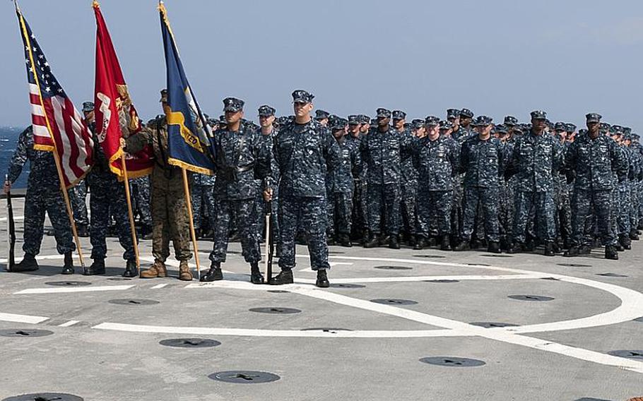 Sailors of the forward-deployed amphibious transport dock ship USS Denver stand in ranks during a change of command ceremony Oct. 18, 2011.
