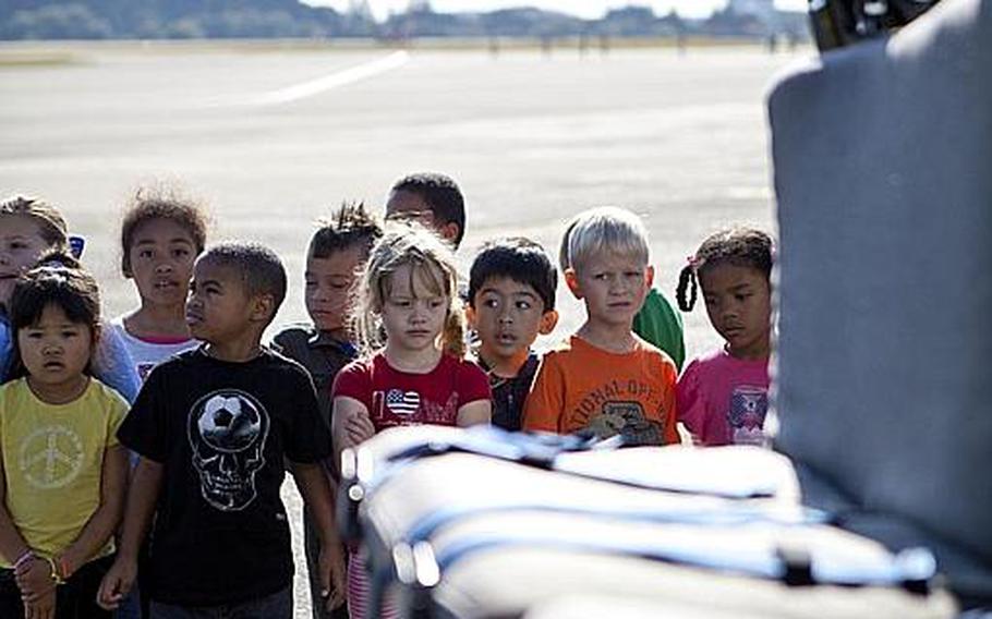 First-graders from Joan K. Mendel Elementary lined up along the flight line Nov. 2, 2011, at Yokota Air Base, Japan, to tour a C-130 cargo plane and a UH-1 helicopter.
