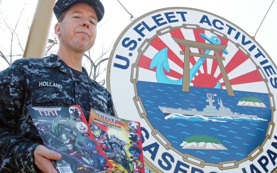 Petty Officer 1st Class Edward Holland shows off the last two issues of "Monster Attack Team," a magazine he co-founded to keep the tokusatsu genre of Japanese fantasy and science fiction monsters and superheroes alive. 