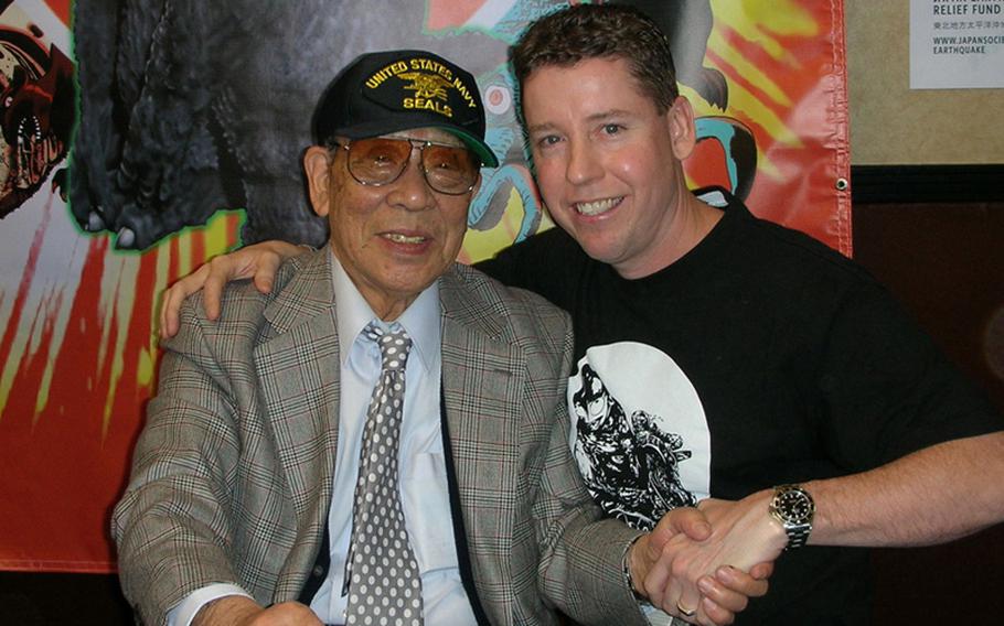 Petty Officer 1st Class Edward Holland, right, shakes hands with the original Godzilla, Haruo Nakajima, at Monsterpalooza in California earlier this year. Holland interviewed the famed Japanese actor for an article in "Monster Attack Team."