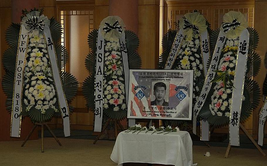 Flowers surround a photo of Cpl. Jang Myung-ki after a ceremony Nov. 23, 2011, at Korea's Demilitarized Zone marking the 27th anniversary of a firefight there in which Jang was killed. Jang was a Korean augmentee to the U.S. Army.

