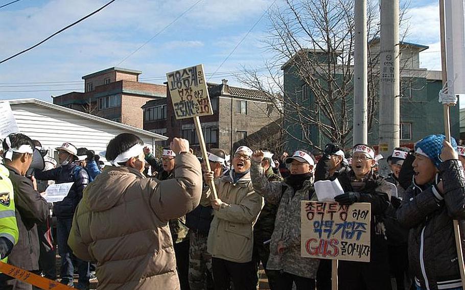 A group of about 50 security guards chant in protest Dec. 1, 2011, across the street from Camp Red Cloud in Uijeongbu. The guards are upset that the company that the week of Nov. 28 took over security for U.S. Army installations in South Korea will only hire them if they accept less pay and longer hours than they worked for the company that formally held the security contract.