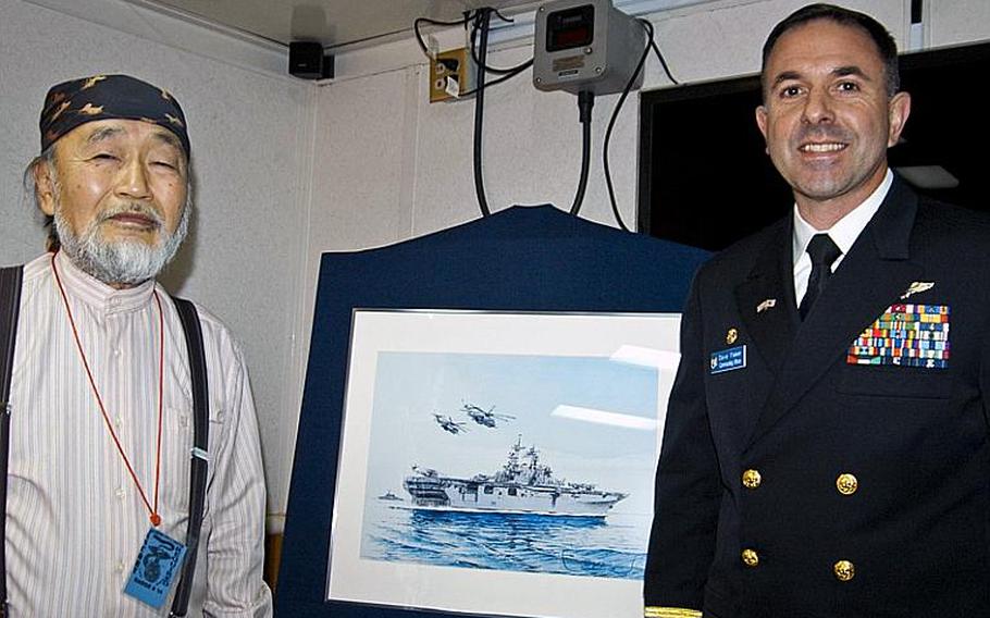 Shima Takashi, left, a 68-year-old renowned painter from Wakayama prefecture, presents a painting he made of the Wasp class multipurpose amphibious assault ship USS Essex to its skipper, Capt. David Fluker, right, Tuesday morning during a small ceremony in the captain's quarters. Takashi painted the Essex in elaborate detail to thank the U.S. military and the ship's crew for their participation in Operation Tomodachi.