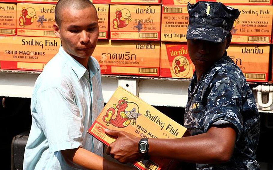 Ensign Elisha Dotson, combat information officer from the Arleigh Burke-class guided missile destroyer USS Lassen, helps a local Thai unload supplies off a truck in Bangkok on Nov. 18. Sailors from the Lassen visited the Thai Red Cross Society distribution center and helped locals load, unload and distribute supplies. In coordination with the U.S. Embassy in Bangkok and the Royal Government of Thailand, U.S. Pacific Command directed theater service components to conduct joint operations in support of disaster assessment and relief operations in Thailand. The III MEF Flood Relief Command Element consisting of joint service members will provide assessment for additional U.S. forces to assist the Royal Government of Thailand.