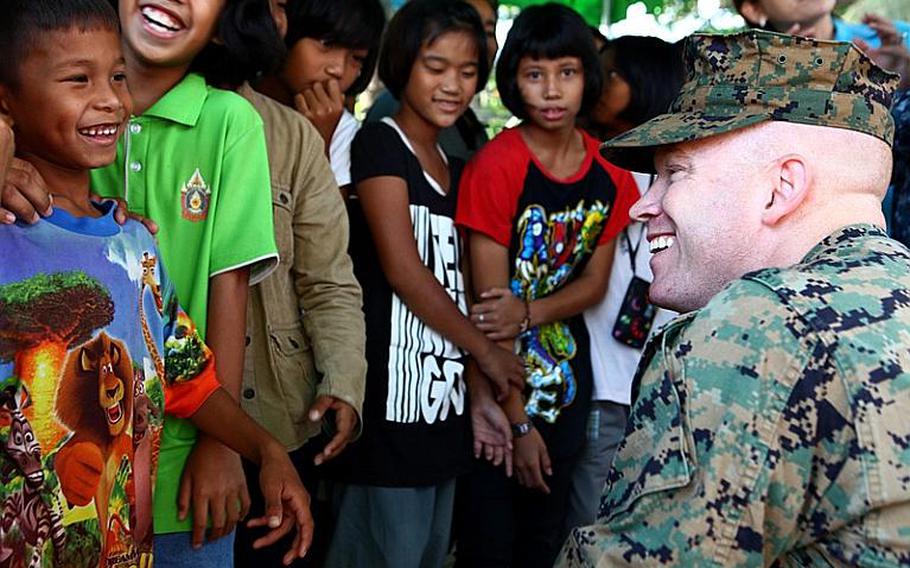 Maj. Jason Wintermute, an anti-terrorism force protection officer, interacts with local children in Lop Buri on Nov. 20. Wintermute, a West-Chester, Penn. native, is with the III Marine Expeditionary Force Flood Relief Command Element. Joint U.S. forces came together to assist the Royal Thai Army Special Warfare College clean community facilities. U.S. forces continue to support the Royal Government of Thailand in their flood relief efforts.