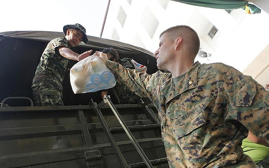 U.S. Marine Maj. Eric Mattson helps load food, water and medical supplies on the Royal Thai  Army truck that was sent out to the flood victims in Bangkok, Thailand, Nov. 19, 2011.  In coordination with the U.S. Embassy in Bangkok and the Royal Government of Thailand, U.S.  Pacific Command directed theater service components to conduct joint operations in support of disaster assessment and relief  operations in Thailand. The III Marine Expeditionary Force Flood Relief Command Element consisting of Marines and sailors from Okinawa, Japan will provide command and control for possible additional U.S. forces to assist the Royal Government of Thailand.