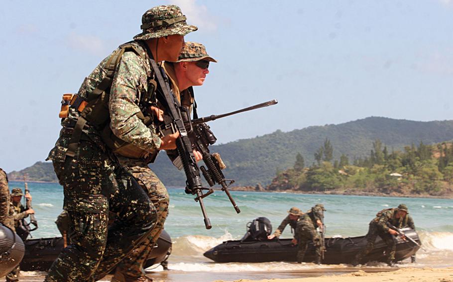 Marines from the 3rd Marine Expeditionary Brigade, headquartered in Okinawa, storm a beach in the Philippines during a 2011 exercise. Sen. John McCain, R-Ariz., said Aug. 21, 2013,during a visit to the Pacific theater that Congress still has concerns over the planning and costs of moving Marines off Okinawa.