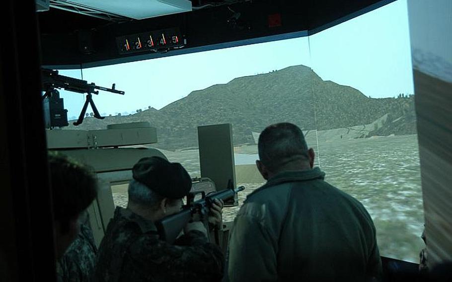 Deputy commander of South Korea-U.S. Combined Forces Command Gen. Kwon Oh-sung takes aim Friday in a battlefield simulator at Camp Casey in South Korea, as U.S. Forces commander Gen. James Thurman, right, looks on. The generals came to the base in connection with a visit there by South Korea Foreign Minister Kim Sung-hwan.