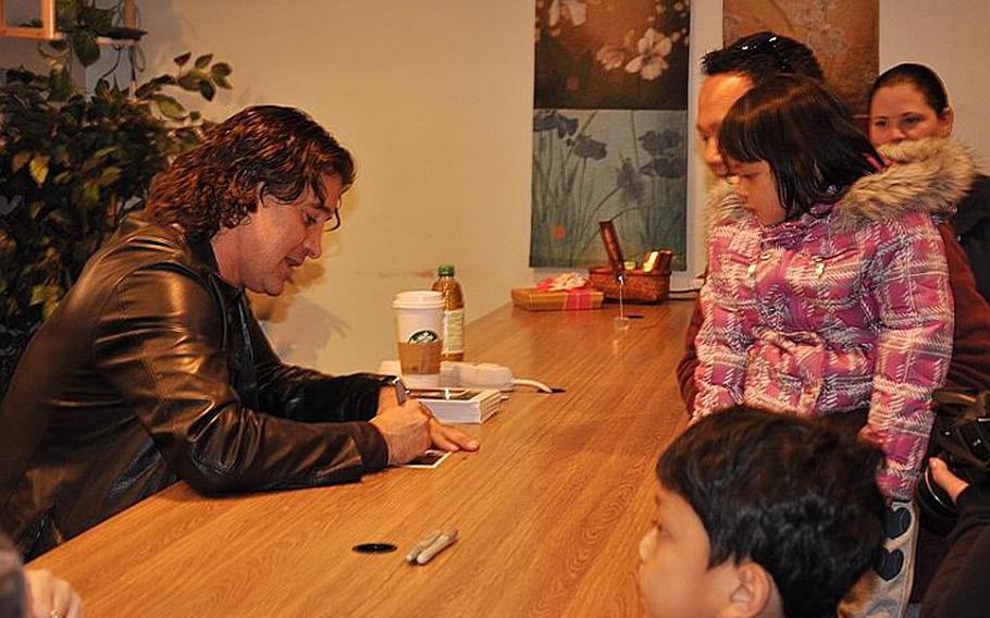 Scott Stapp, the lead singer of Creed, signs autographs for Petty Officer Li Tamondong and his children, Theresa May and Mikael at the Yokosuka United Service Organizations office on March 18, 2012. Stapp and his wife, Jaclyn, said they wanted to thank the servicemembers for their relief efforts during Operation Tomodachi.