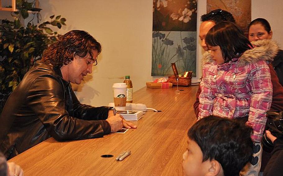 Scott Stapp, the lead singer of Creed, signs autographs for Petty Officer Li Tamondong and his children, Theresa May and Mikael at the Yokosuka United Service Organizations office on March 18, 2012. Stapp and his wife, Jaclyn, said they wanted to thank the servicemembers for their relief efforts during Operation Tomodachi.